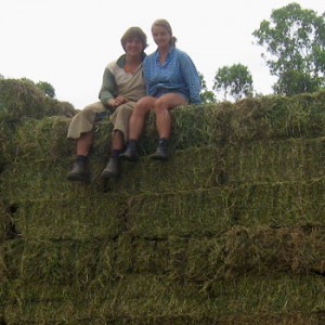 Work and Travel Teilnehmer Maria und Simon auf einem Stapel Heuballen