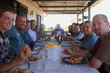 Gruppe von Teilnehmern sitzt beim gemeinsamen Lunch auf der Veranda